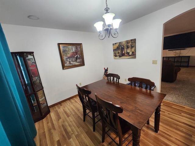 dining space with a chandelier and light hardwood / wood-style floors