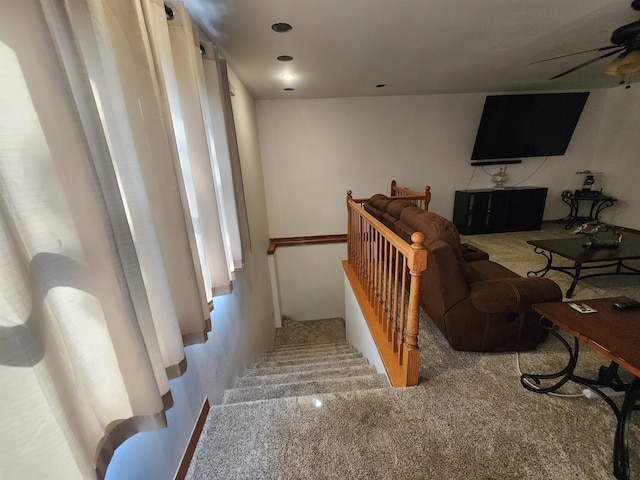 stairway featuring carpet floors and ceiling fan