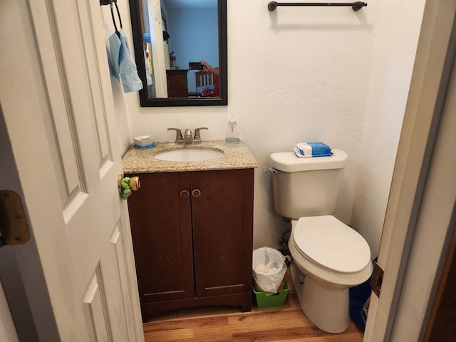 bathroom featuring hardwood / wood-style flooring, vanity, and toilet