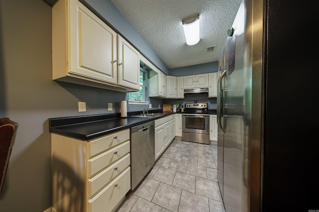 kitchen featuring stainless steel appliances, sink, light tile patterned floors, a textured ceiling, and exhaust hood