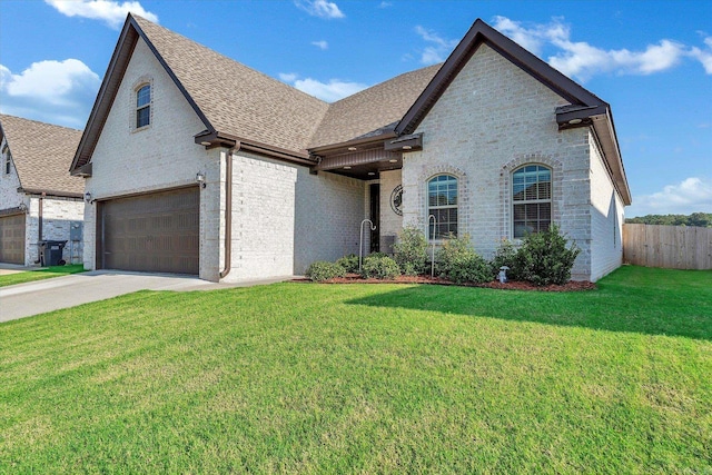 french country style house featuring a garage and a front yard