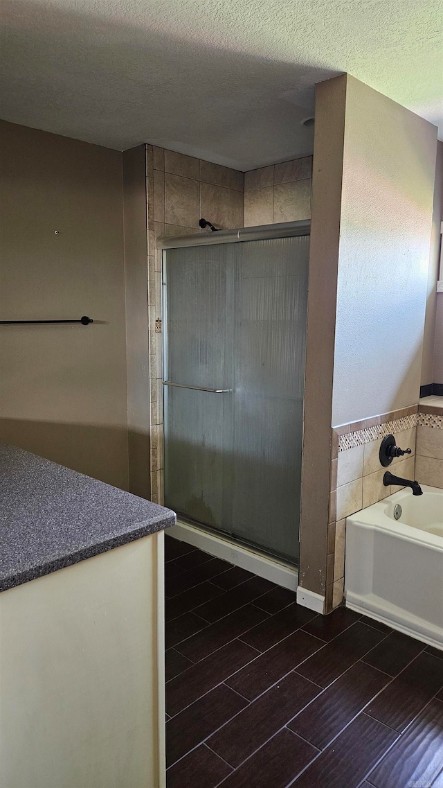 bathroom featuring shower with separate bathtub, a textured ceiling, and tile patterned floors