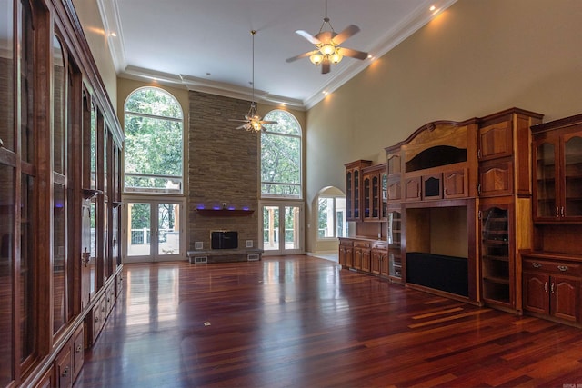 unfurnished living room with ornamental molding, a wealth of natural light, french doors, and a towering ceiling