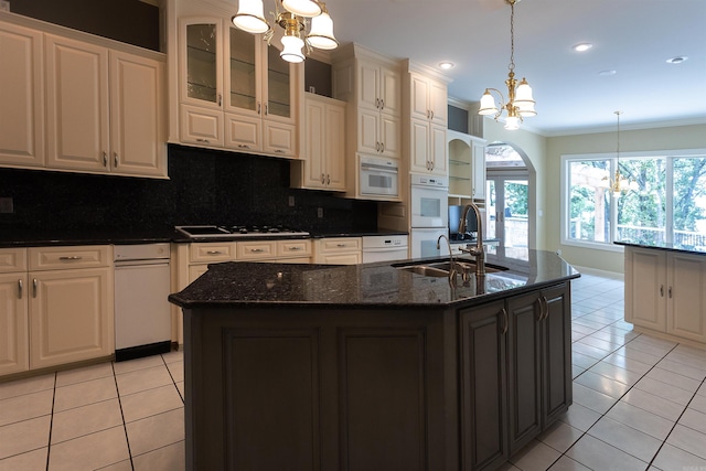 kitchen with light tile patterned floors, crown molding, a chandelier, a sink, and gas cooktop