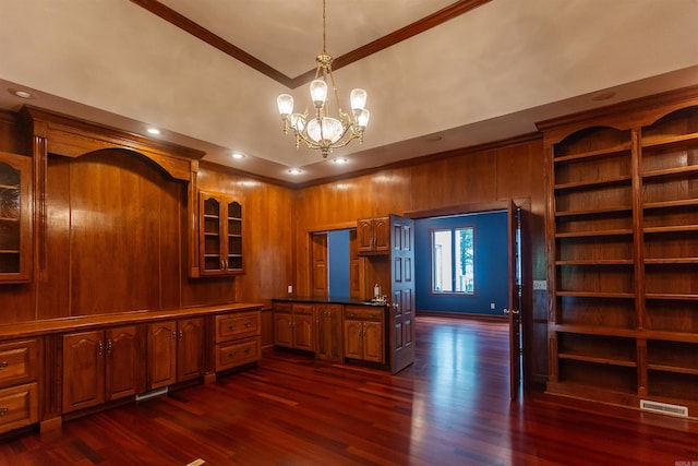 interior space with dark wood-style floors, visible vents, brown cabinetry, glass insert cabinets, and ornamental molding