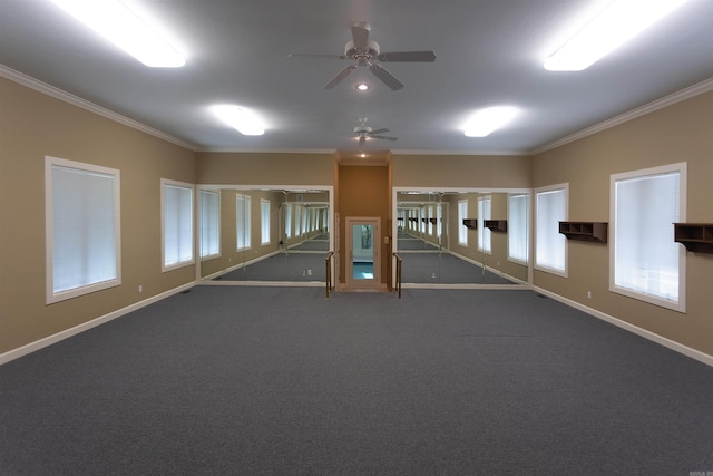 empty room featuring a ceiling fan, dark carpet, crown molding, and baseboards