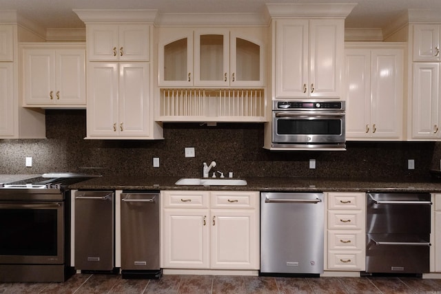 kitchen featuring backsplash, white cabinetry, stainless steel appliances, and a sink