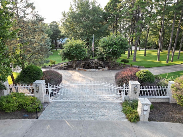 view of home's community with a fenced front yard, a gate, and a lawn