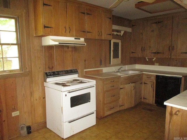 kitchen with under cabinet range hood, wood walls, dishwasher, electric stove, and a sink