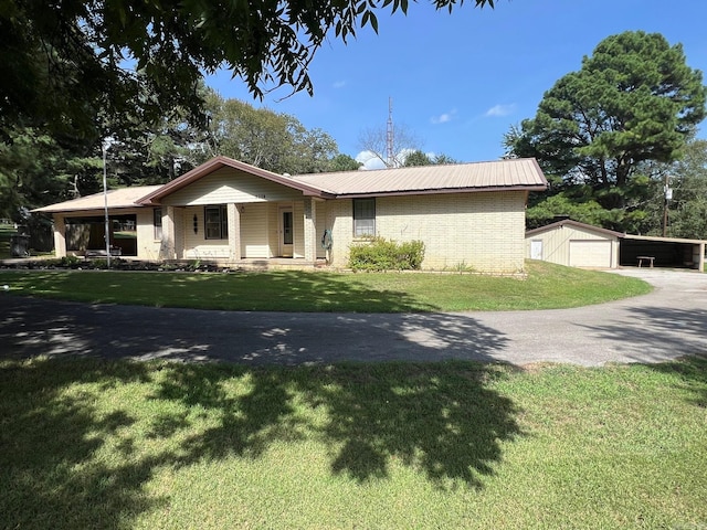 ranch-style house featuring a garage, an outdoor structure, and a front lawn