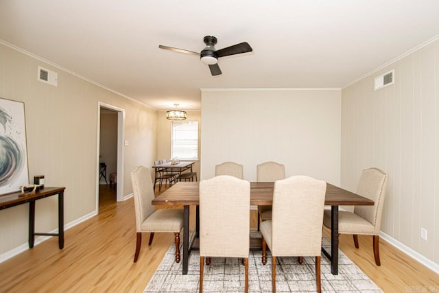 dining space with light hardwood / wood-style flooring, ornamental molding, and ceiling fan