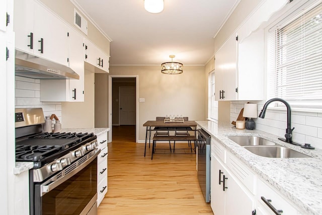 kitchen featuring white cabinetry, appliances with stainless steel finishes, tasteful backsplash, and light wood-type flooring