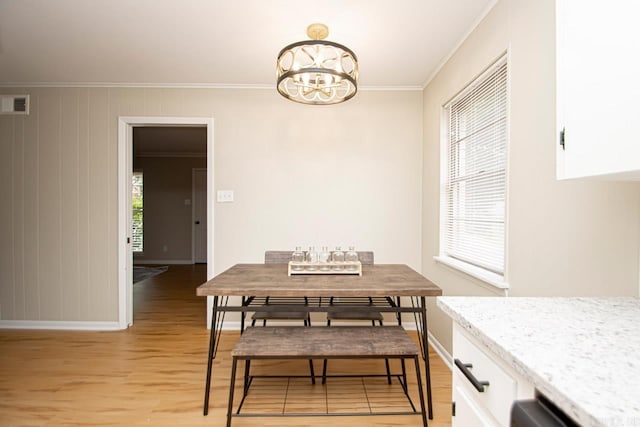 dining area featuring an inviting chandelier, light hardwood / wood-style floors, and ornamental molding