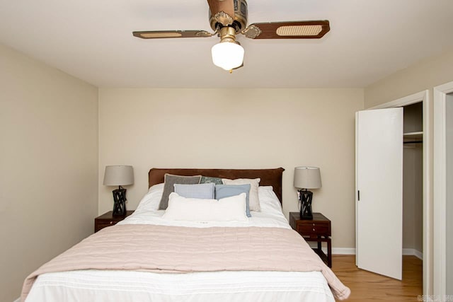 bedroom with ceiling fan, light hardwood / wood-style floors, and a closet