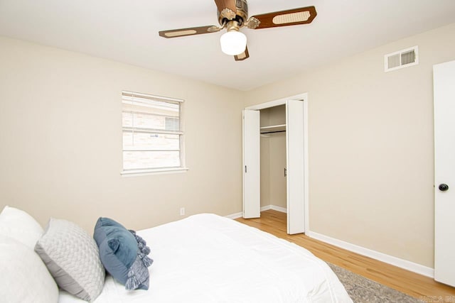 bedroom with ceiling fan, light hardwood / wood-style floors, and a closet