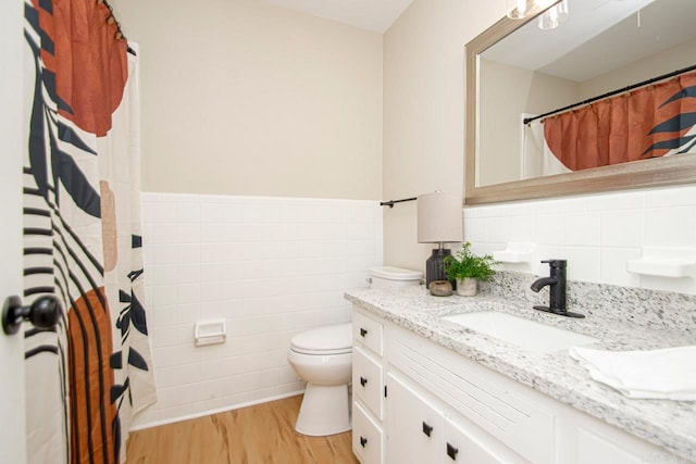 bathroom featuring vanity, tile walls, hardwood / wood-style floors, toilet, and backsplash