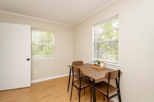 dining space featuring a healthy amount of sunlight, light hardwood / wood-style floors, and crown molding