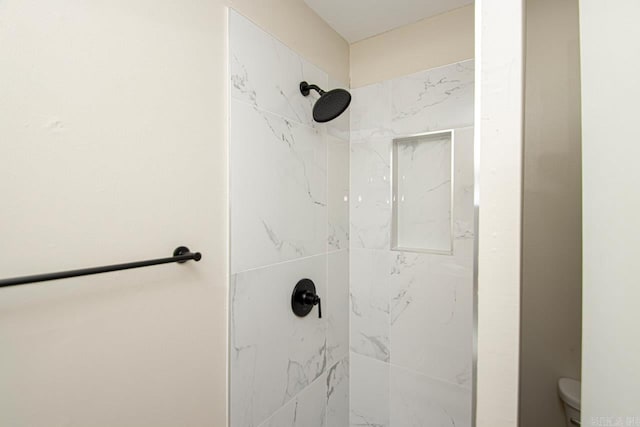 bathroom with tiled shower and toilet