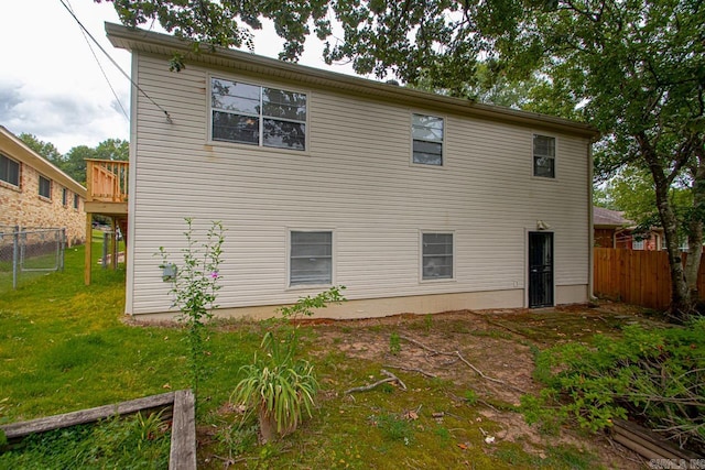 back of house featuring a yard and a wooden deck