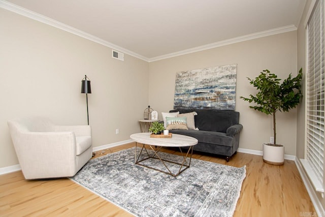 living room with ornamental molding and light hardwood / wood-style floors