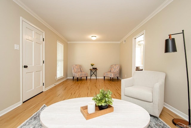 living area with ornamental molding and light hardwood / wood-style floors