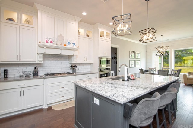 kitchen featuring sink, a kitchen island with sink, dark hardwood / wood-style flooring, and white cabinets