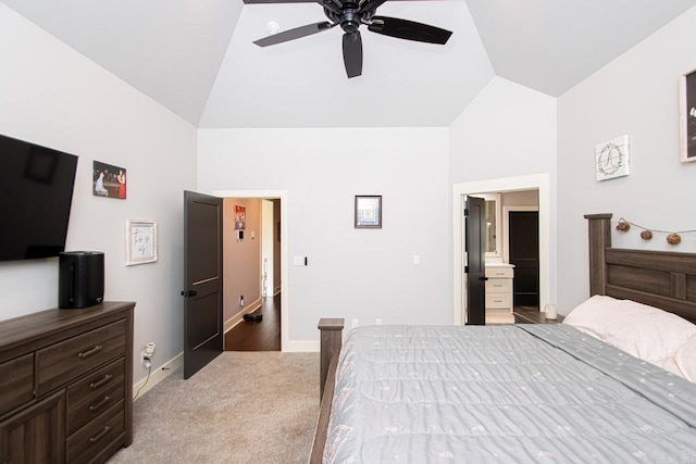 carpeted bedroom with ensuite bathroom, ceiling fan, and vaulted ceiling