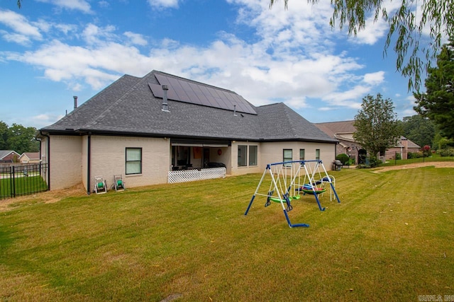 back of house with a yard and a playground