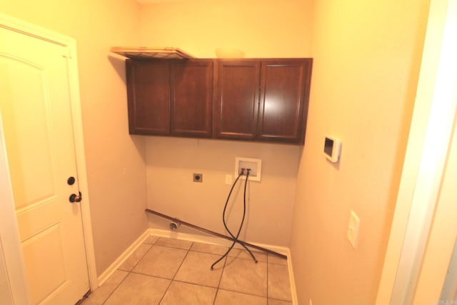 laundry room with cabinets, light tile patterned flooring, hookup for a washing machine, and hookup for an electric dryer