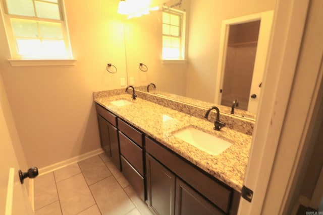 bathroom featuring tile patterned floors, a wealth of natural light, and double sink vanity