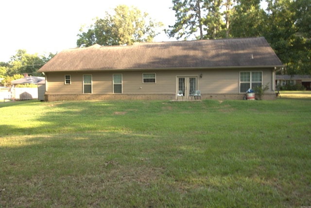 back of property with french doors and a yard