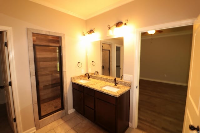 bathroom with an enclosed shower, ornamental molding, tile patterned floors, and double sink vanity