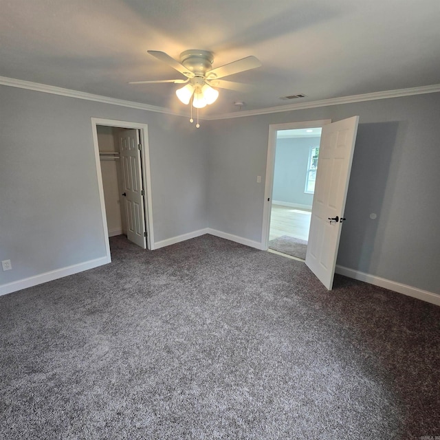 unfurnished bedroom featuring ornamental molding, a closet, carpet floors, and ceiling fan