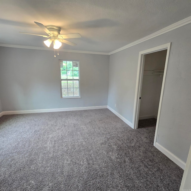 interior space with a textured ceiling, crown molding, carpet floors, and ceiling fan