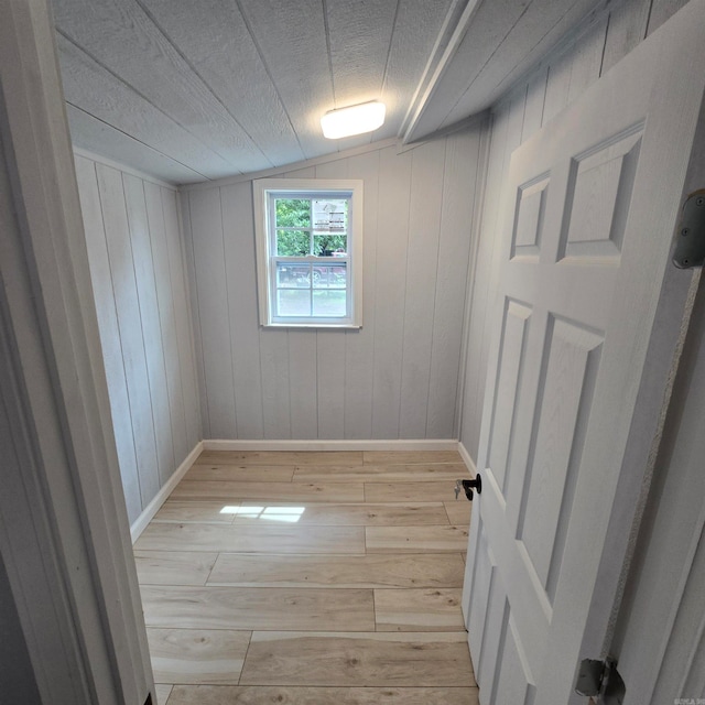 unfurnished room featuring light hardwood / wood-style flooring and lofted ceiling