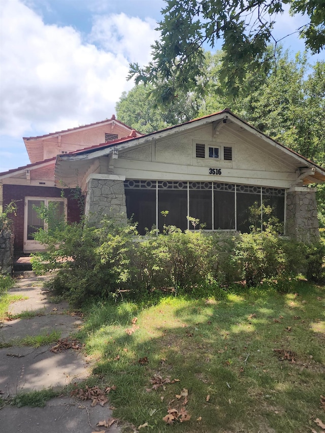 exterior space featuring a yard and a sunroom