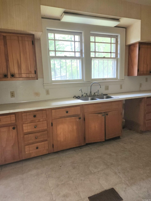 kitchen featuring light tile patterned floors and sink