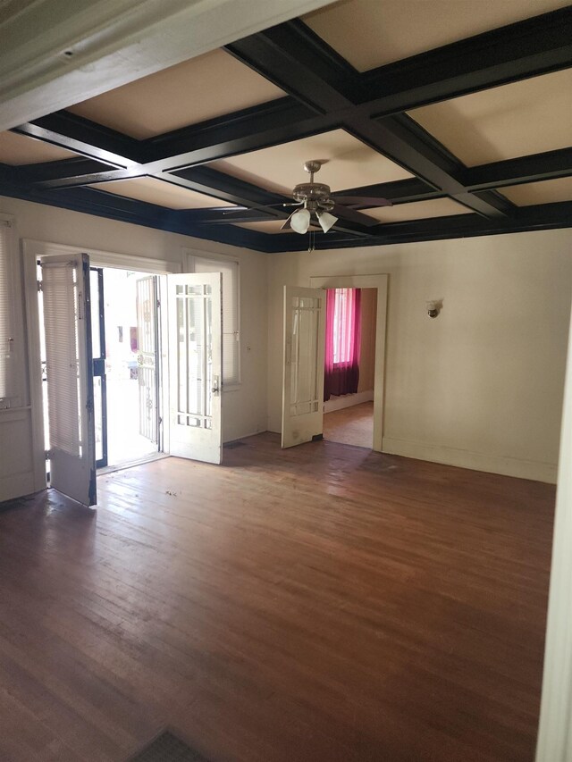 empty room with coffered ceiling, wood-type flooring, beamed ceiling, and ceiling fan