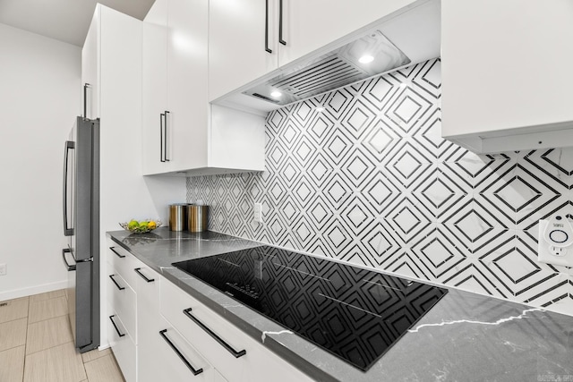 kitchen with white cabinetry, tasteful backsplash, light tile patterned floors, custom exhaust hood, and stainless steel fridge