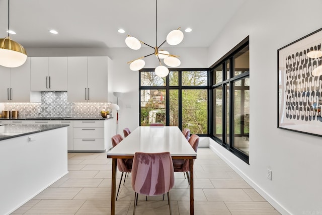 kitchen featuring light tile patterned flooring, decorative backsplash, pendant lighting, and white cabinetry