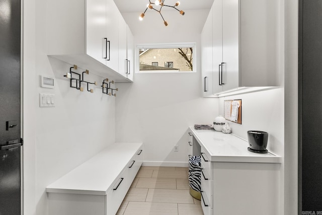 mudroom with a notable chandelier and light tile patterned floors