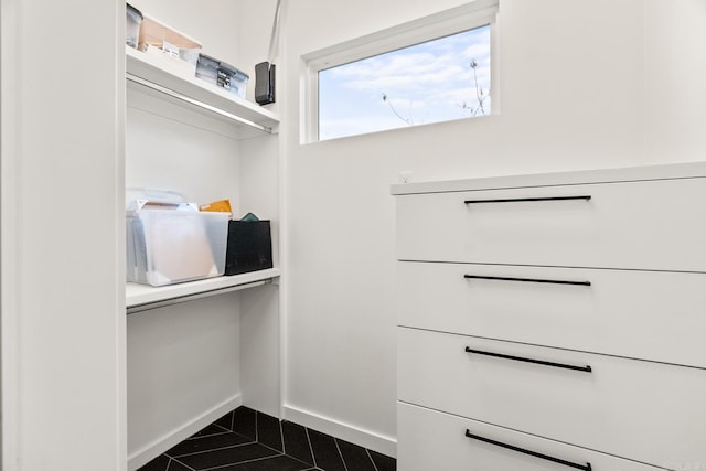 walk in closet featuring dark tile patterned floors