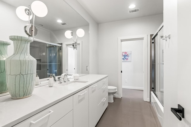 full bathroom featuring vanity, toilet, combined bath / shower with glass door, and tile patterned flooring