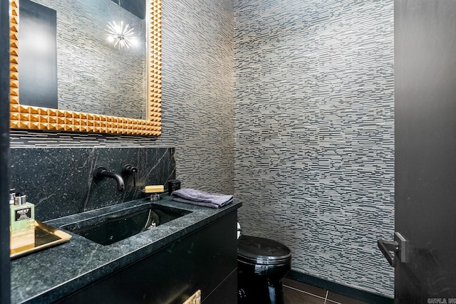 bathroom featuring tile patterned flooring, toilet, vanity, tile walls, and decorative backsplash