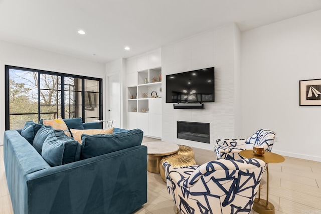 living room featuring built in features and a tiled fireplace