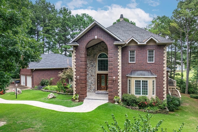 view of front facade featuring brick siding, a chimney, a shingled roof, and a front lawn