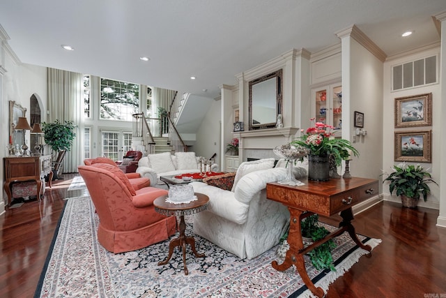 living area with visible vents, baseboards, a fireplace, stairs, and dark wood-type flooring