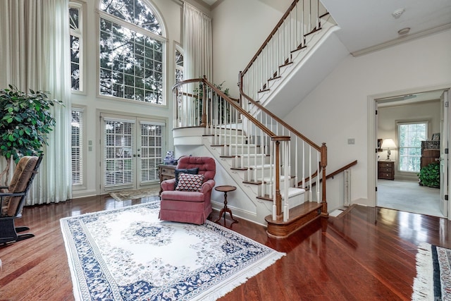 foyer with stairway, a high ceiling, wood finished floors, and ornamental molding