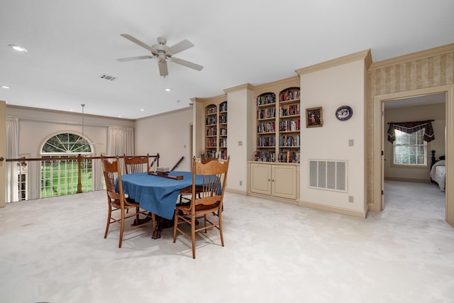 carpeted dining room featuring visible vents, baseboards, and crown molding