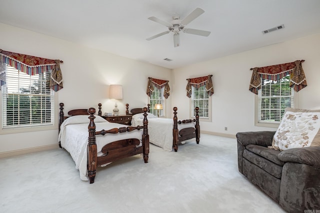 bedroom with visible vents, light carpet, baseboards, and a ceiling fan